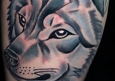 Black and grey realistic wolf head tattoo with expressive eyes and soft shading on the forearm, custom tattoo by Clockwork Tattoo Shop in Centereach, Long Island, New York